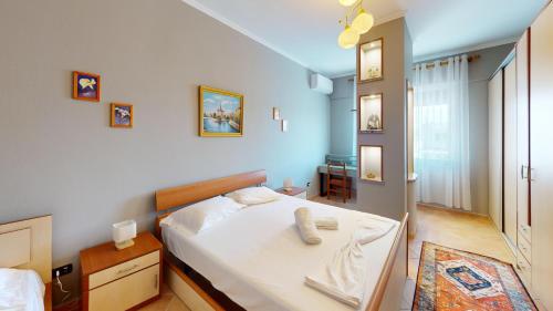 a bedroom with a bed with a white sheets at Coastal Nest Apartments in Durrës