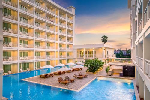 an image of a hotel pool with tables and umbrellas at Chanalai Hillside Resort, Karon Beach in Karon Beach