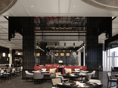 a dining room with tables and chairs and chandeliers at Grand Mercure Batam Centre in Batam Center