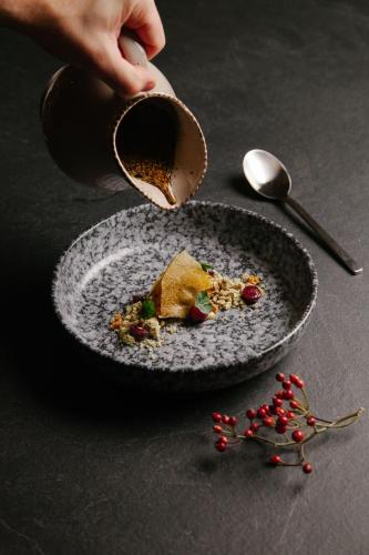 a person holding a cup of coffee next to a plate of food at Landhotel Gasthof Bauböck in Andorf