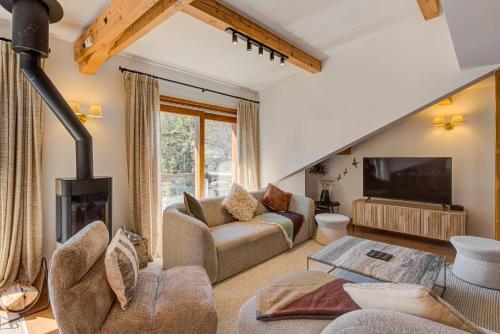 un salon avec un canapé et une cheminée dans l'établissement Les Melées Apartments - Alpes Travel - Argentiere, à Chamonix-Mont-Blanc