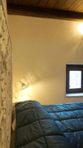 a bedroom with a blue bed and a window at Festina Lente - Guest House in Santo Stefano di Sessanio