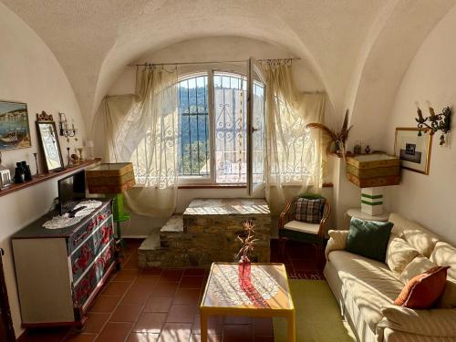 ein Wohnzimmer mit einer Couch und einem Fenster in der Unterkunft Casa Belvedere in Diano San Pietro