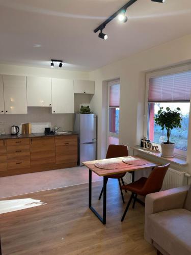 a kitchen and living room with a table and chairs at Wooden Dream with Terrace in Siedlce