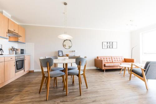 a kitchen and living room with a table and chairs at Fehmarnstrand 77 Whg 2 in Staberdorf