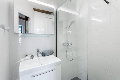 une salle de bain blanche avec un lavabo et une douche dans l'établissement L'Emery - Central & Confortable, à Nantes
