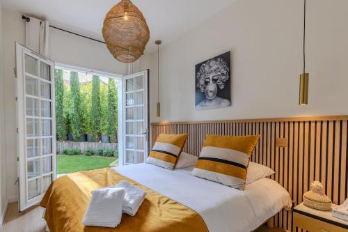 une chambre avec un lit et une grande fenêtre dans l'établissement Villa Bilacoro Cœur d'Hossegor, à Soorts-Hossegor
