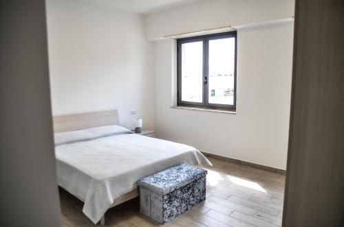 Un dormitorio blanco con una cama y una ventana. en Appartamento Siderno sul mare bilocale, en Siderno Marina