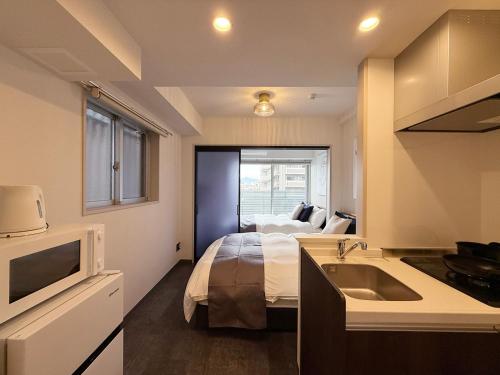 a bedroom with a bed and a sink in it at Lifement - 1min to Peace Park, Modern and Secure Apt in Hiroshima
