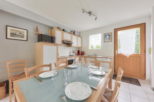 une salle à manger avec une table et des chaises et une cuisine dans l'établissement Jolie maison pour 5 - Pointe de Kerners Arzon, à Arzon