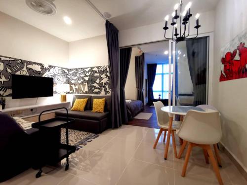 een woonkamer met een bank en een tafel bij The Shore Artsy Studio Kota Kinabalu in Kota Kinabalu
