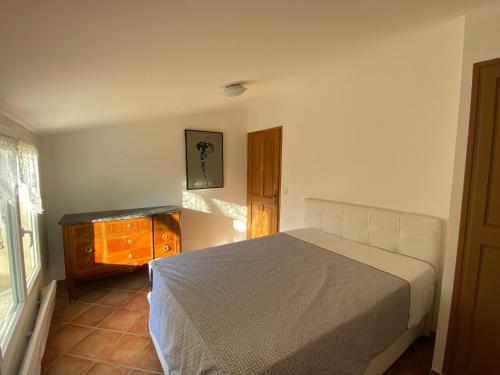 une chambre avec un lit, une commode et une fenêtre dans l'établissement Petite maison de campagne, à Digne-Les-Bains
