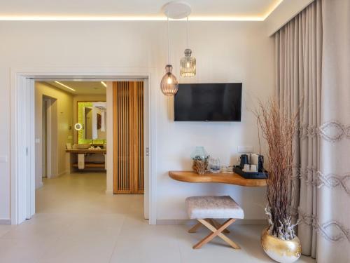 a living room with a table and a television on the wall at Anax Resort and Spa in Agios Ioannis Mykonos