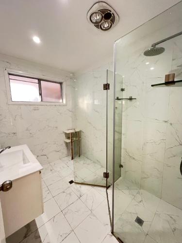 a bathroom with a shower and a sink at J Room in Baulkham Hills