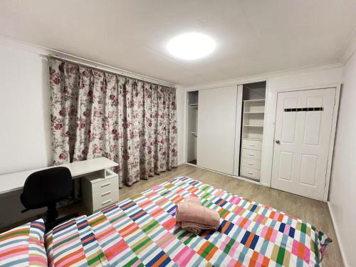 a bedroom with a bed and a desk and a chair at J Room in Baulkham Hills