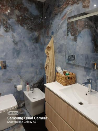 a bathroom with a sink and a toilet and a mirror at marina in Acantilado de los Gigantes