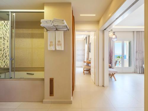 a bathroom with a walk in shower and towels at Anax Resort and Spa in Agios Ioannis Mykonos