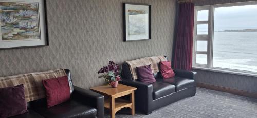 a living room with two chairs and a table at Royal Court Hotel in Portrush