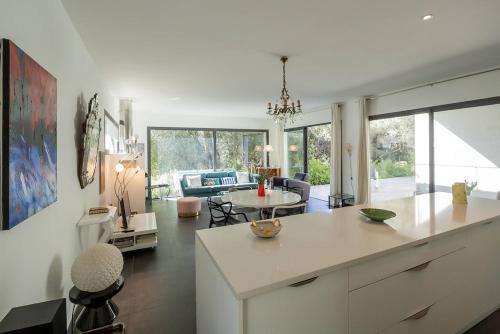 une cuisine et un salon avec une table et une salle à manger dans l'établissement Belle villa 3 chambres au cœur du maquis, à Porto-Vecchio