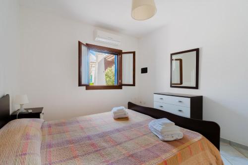 een slaapkamer met een bed met handdoeken erop bij Villa Mery Villaggio Chiusurelle in Torre Lapillo