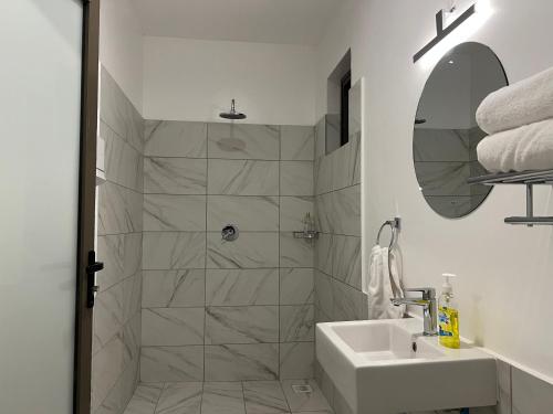 a white bathroom with a shower and a sink at Lihanda Villa in Kilifi