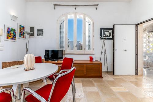 sala de estar con mesa y sillas rojas en Villa Bianca Marina, en Villanova di Ostuni