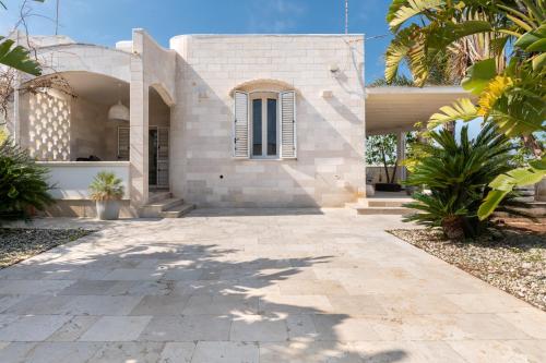 una casa con una pasarela de piedra delante de ella en Villa Bianca Marina, en Villanova di Ostuni