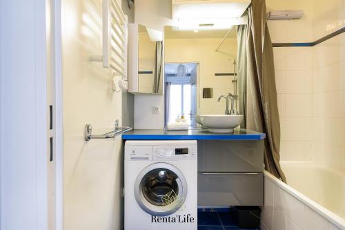 une salle de bain avec une machine à laver et un lavabo dans l'établissement Buxengeorgiens Delouvrier - T2 - 7min DisneyLand, à Bussy-Saint-Georges