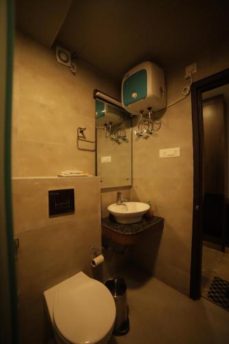 a bathroom with a toilet and a sink at Aman The Lake Side Nainital in Nainital