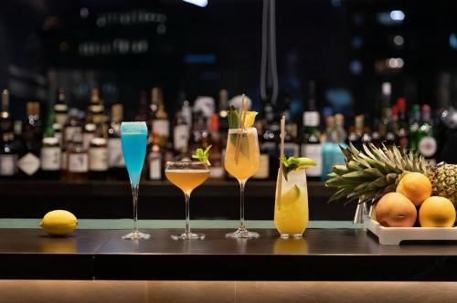 a group of four champagne glasses sitting on a bar at Elegant International Hotel Shanghai - Bund Sichuan Road North Metro Station Branch in Shanghai
