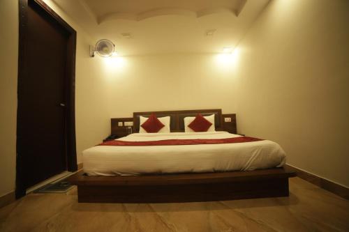 a bedroom with a bed with red pillows on it at Aman The Lake Side Nainital in Nainital