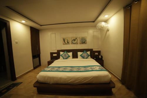 a bedroom with a large bed in a room at Aman The Lake Side Nainital in Nainital