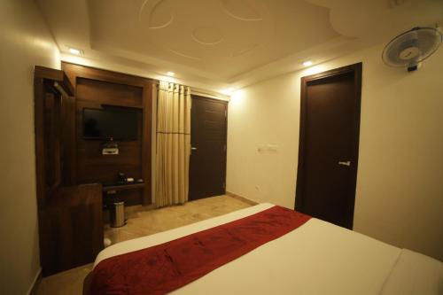 a hotel room with a bed and a television at Aman The Lake Side Nainital in Nainital
