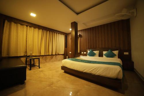 a hotel room with a bed and a table at Aman The Lake Side Nainital in Nainital