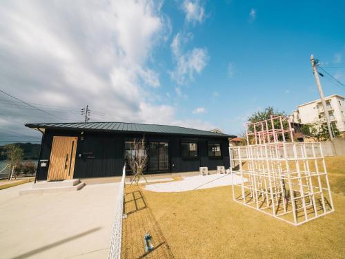 a black house with a fence and a playground at OceanVilla Naruto in Naruto