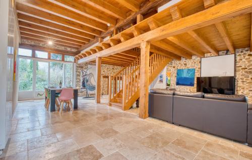 un grand salon avec un mur en pierre et des plafonds en bois dans l'établissement Pet Friendly Home In Jumilhac-Le Grand, à Jumilhac-le-Grand