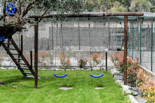 three swings in the grass in a yard at RUSTICO ALLE MURA Love & Bike in Toirano