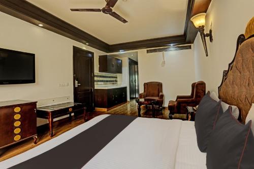 a hotel room with a bed and a tv at Super Townhouse The Royce New Friends Colony in New Delhi