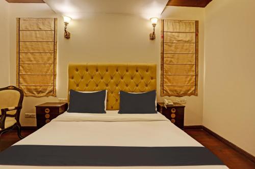 a bedroom with a large bed and two windows at Super Townhouse The Royce New Friends Colony in New Delhi