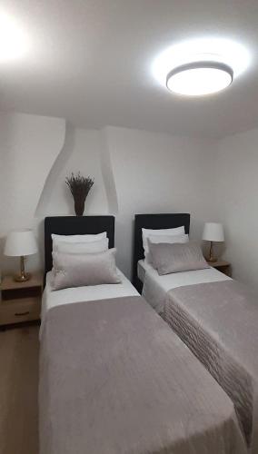 two beds in a room with two lamps at Old Town Lux in Baška