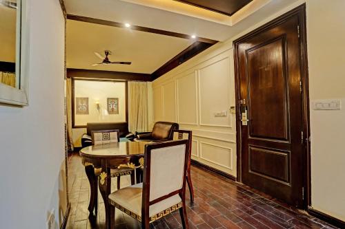 a room with a table and a chair and a door at Super Townhouse The Royce New Friends Colony in New Delhi