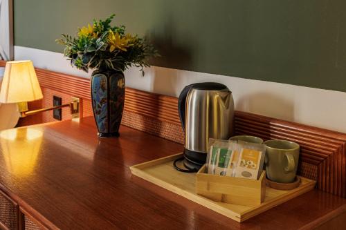 a coffee maker and a vase on a wooden table at Hotel alla Grotta in Lazise