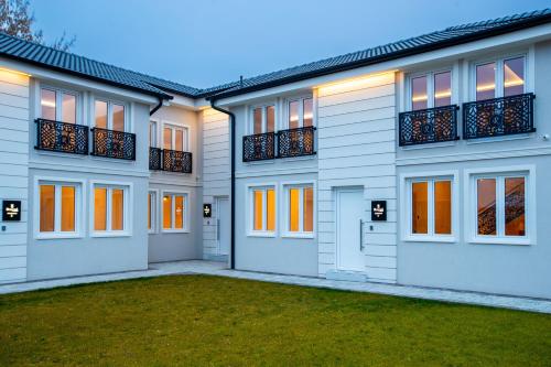 a large white house with orange doors and windows at Royal Crown Apartments in Subotica