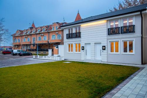 a building with a grass yard in front of it at Royal Crown Apartments in Subotica