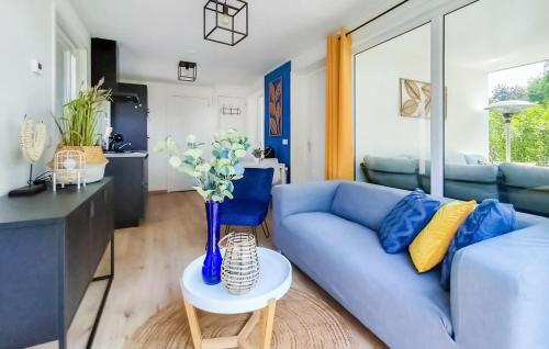 a living room with a blue couch and a table at Chalet met privé tuin & hottub Zeeland VP064 in Heinkensand