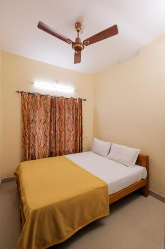 a bedroom with a bed with a ceiling fan at sky blue villa in Vythiri