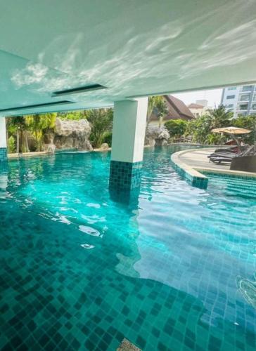 a swimming pool with blue water in a building at Club Royal Apartments in North Pattaya