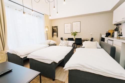 a room with three beds and a table with a laptop at City-Apartment Kreuzviertel-Lädchen-60 qm in Münster