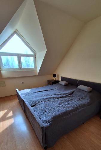 a bedroom with a large bed with a large window at Gutenberg Villa in Balatonalmádi