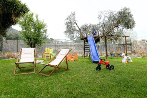 a playground with two chairs and a slide in a yard at RUSTICO ALLE MURA Love & Bike in Toirano